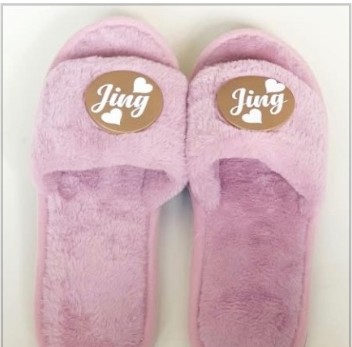 Pink fluffy slippers with the name Jing on the straps