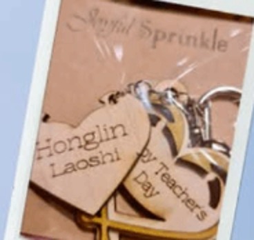 Wooden heart keychains engraved with names and a teacher's day message